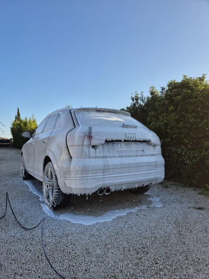 alt="Lavage automobile complet, carrosserie brillante, pare-brise nettoyé, pneus cirés, finition soignée, detailing professionnel"